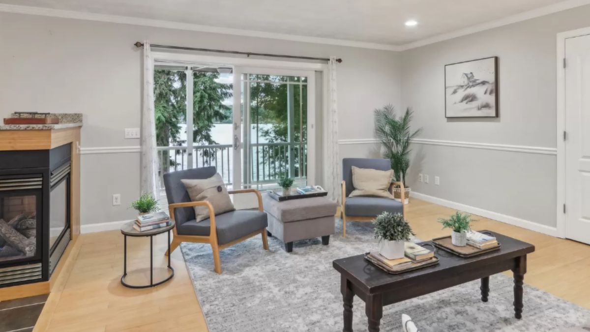 A living room with windows, a fireplace, chairs, and coffee tables.