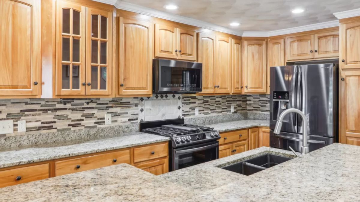 A kitchen with countertops, a sink, cabinets, and kitchen appliances.