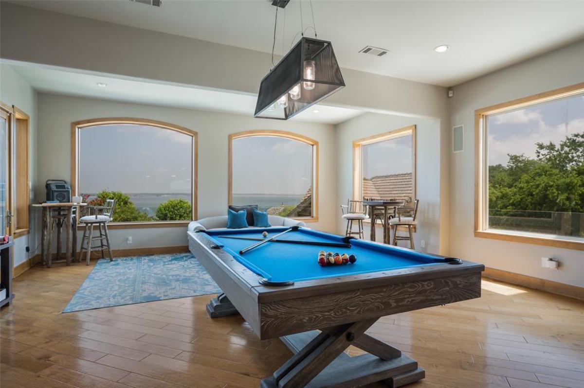 Billiards room with hardwood floor and glass windows.