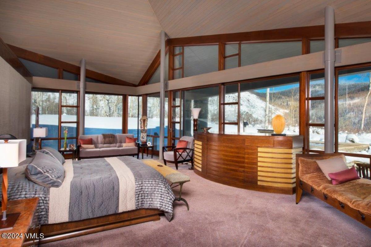 Bedroom with carpet flooring and floor-to-ceiling glass walls.