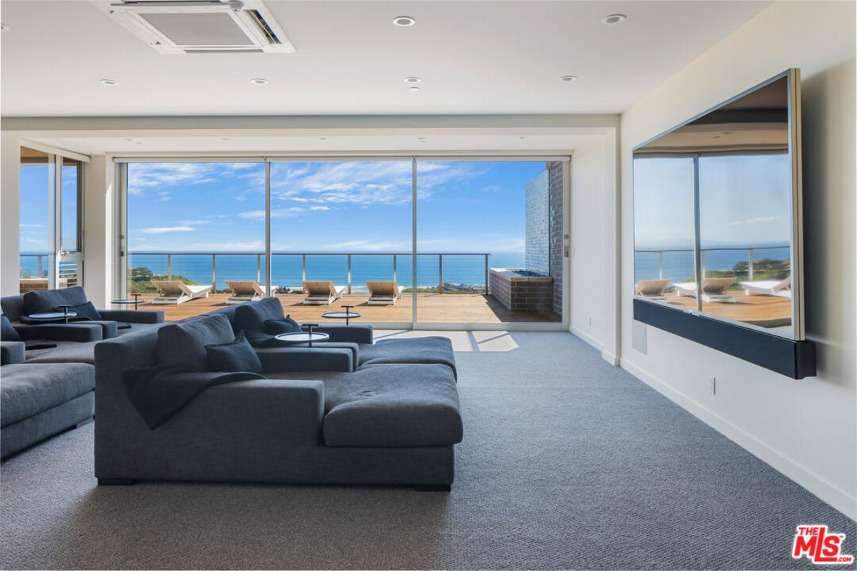 Media room with couches and a large TV.