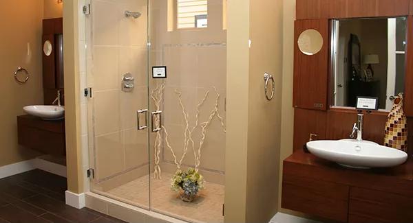 Primary bathroom with a walk-in shower flanked by his and her vanities.