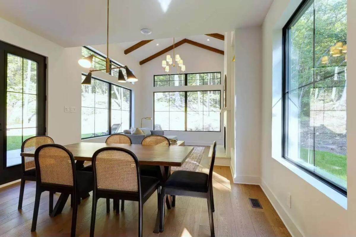 Dining area with a rectangular dining set illuminated by a brass chandelier.