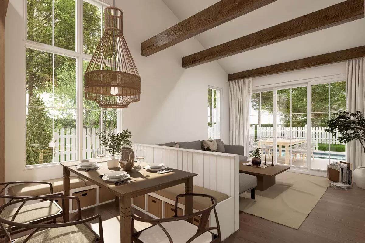 Dining area and living room crowned by a vaulted ceiling with exposed beams.