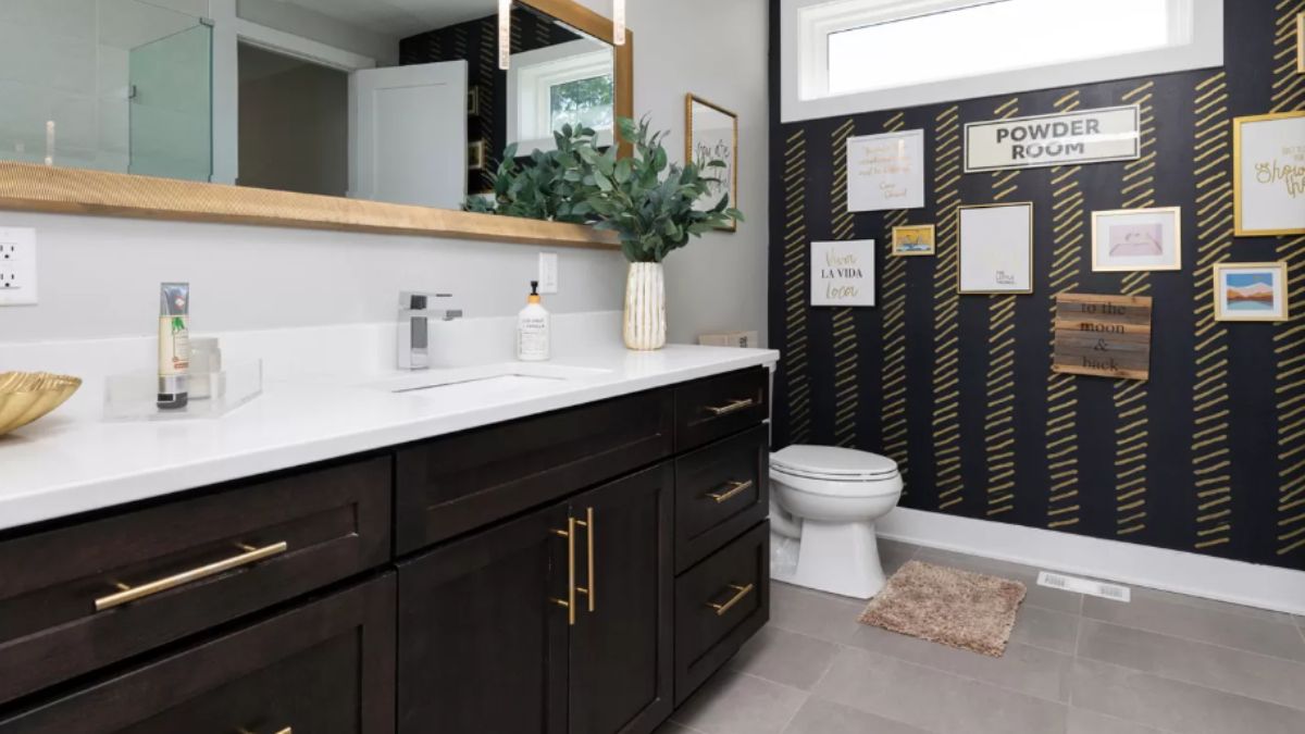 A bathroom with a vanity, mirror, cabinets, and toilet.