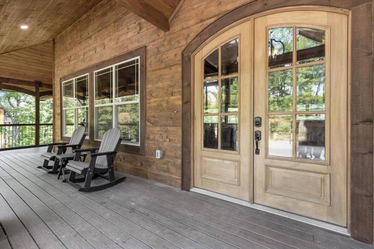 Entry porch with dark wood loungers and a French front door.