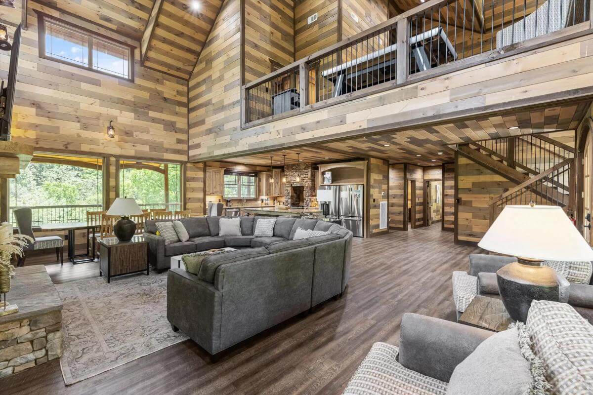 The living room includes a tall vaulted ceiling and a view of the balcony.