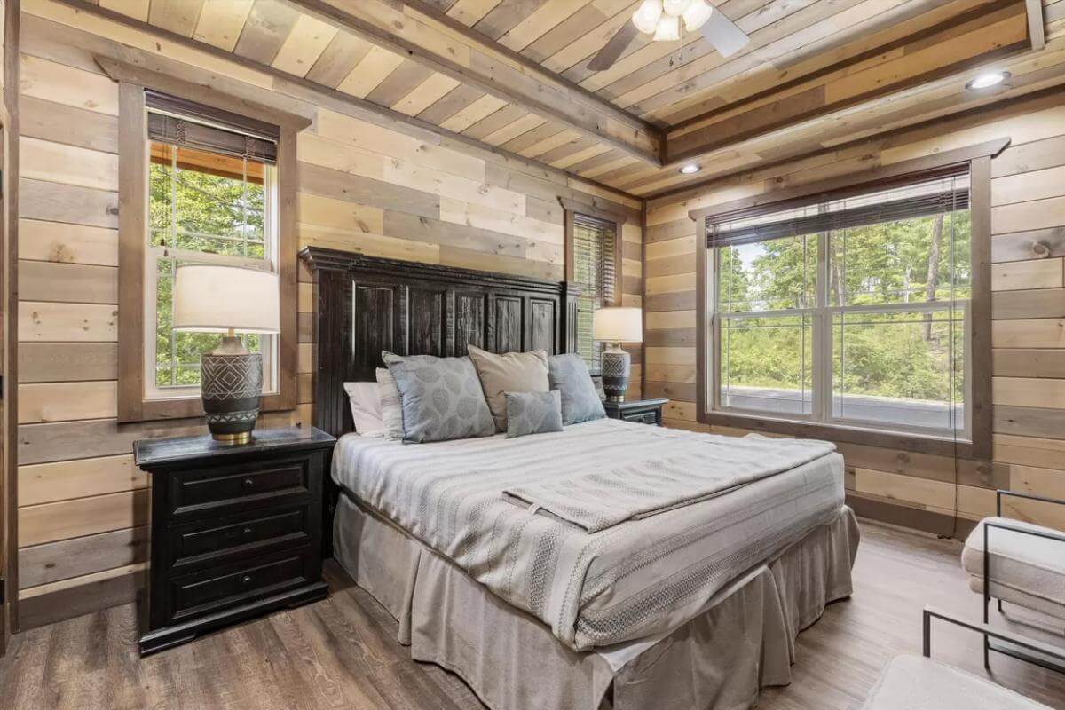 Bedroom with dark wood furnishings and a fan mounted on the tray ceiling.