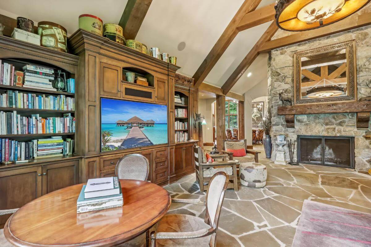 The family room includes a stone fireplace and a TV flanked by built-in bookcases.