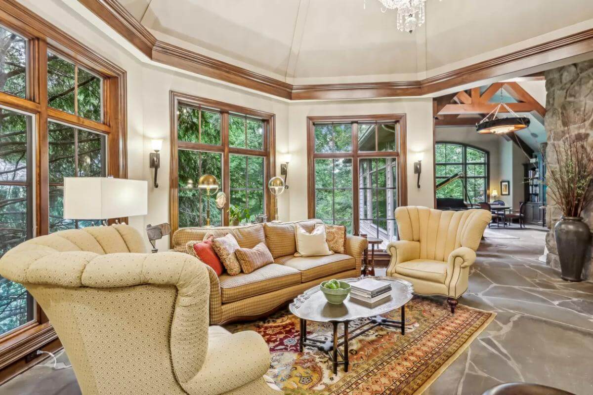 Living room with a leather sofa, wingback chairs, an oval coffee table over the vintage area rug.