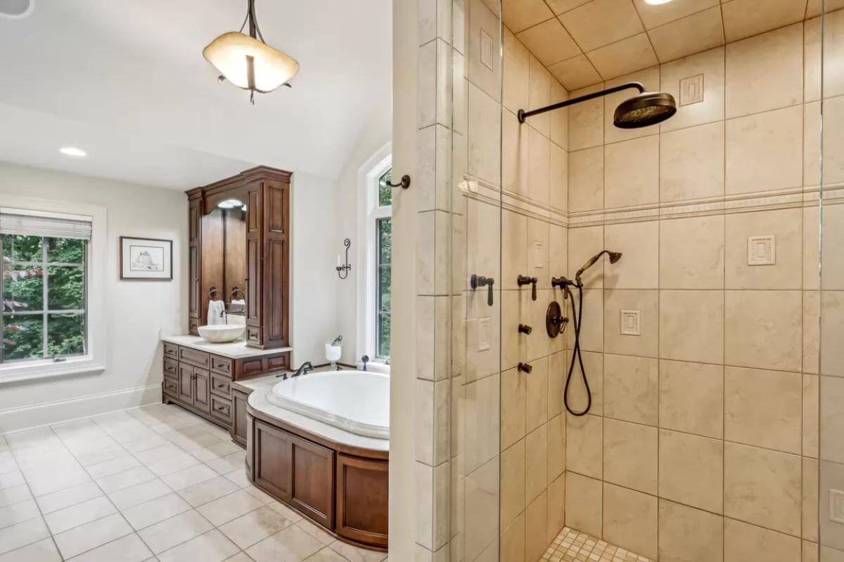 The primary bathroom includes a bathtub and a tiled shower fitted with wrought iron fixtures.