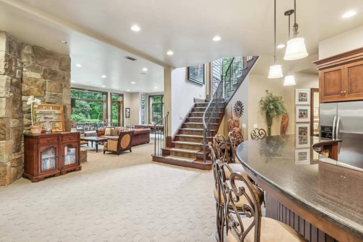 Basement with a stone accent wall, a living space, and a wet bar.