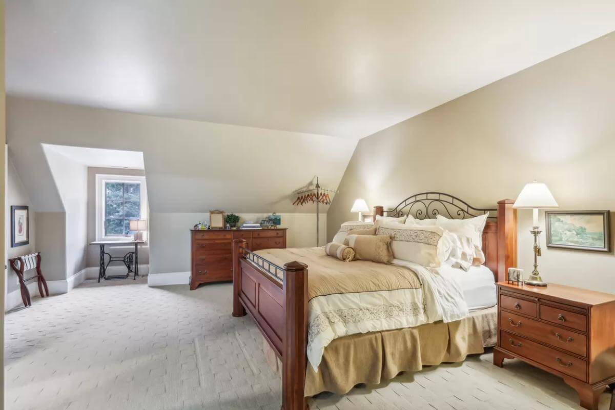 Bedroom with a wooden bed and matching cabinets under a vaulted ceiling.