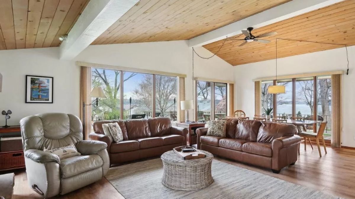 A living room with a wooden floor, rug, couches, and a center table.