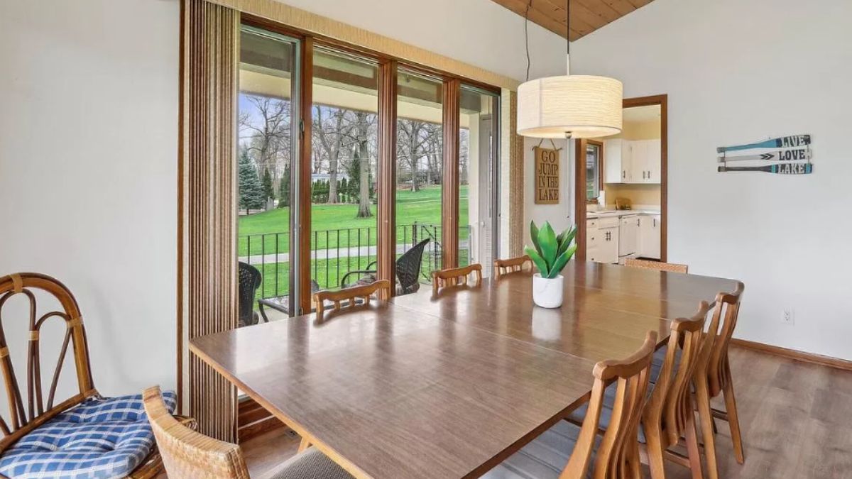 A dining room with a wooden dining table surrounded by dining chairs.