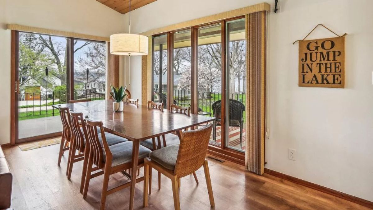 A dining room with a wooden dining table surrounded by dining chairs.