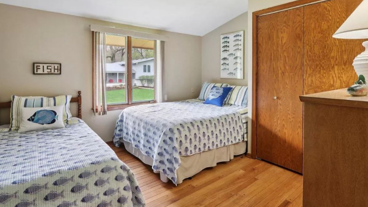 A bedroom with two beds and a window.