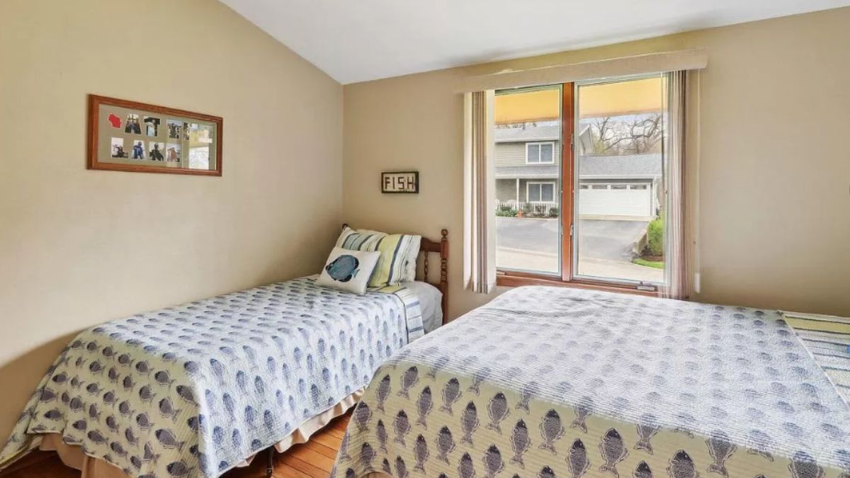 A bedroom with two beds and a window.