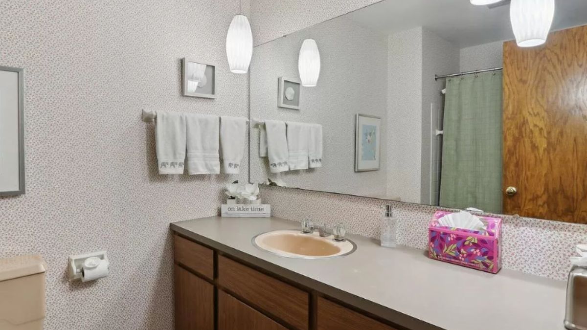 A bathroom with a vanity, cabinet, and mirror.