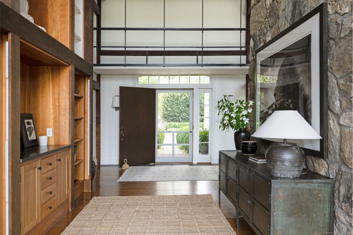 A foyer with cabinets, rugs, and a wooden floor.