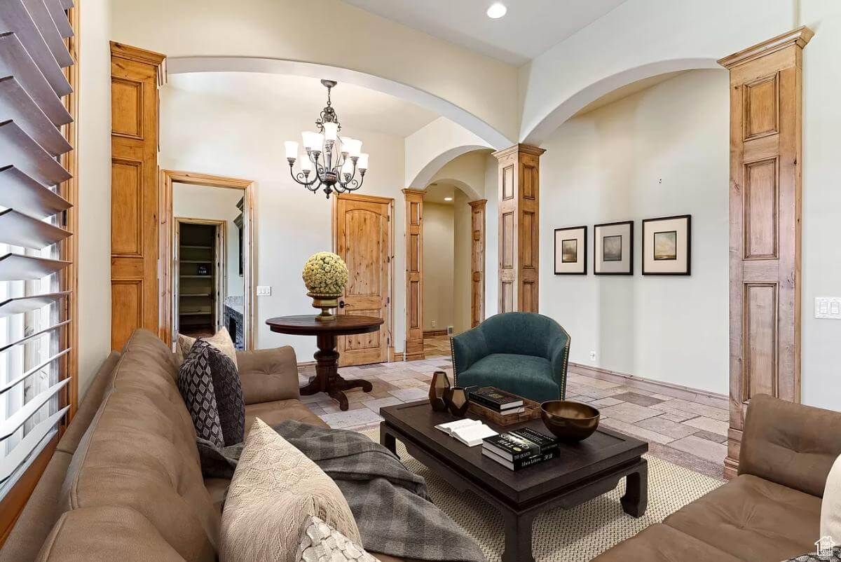 The sitting room includes open archways adorned by wood pillars.