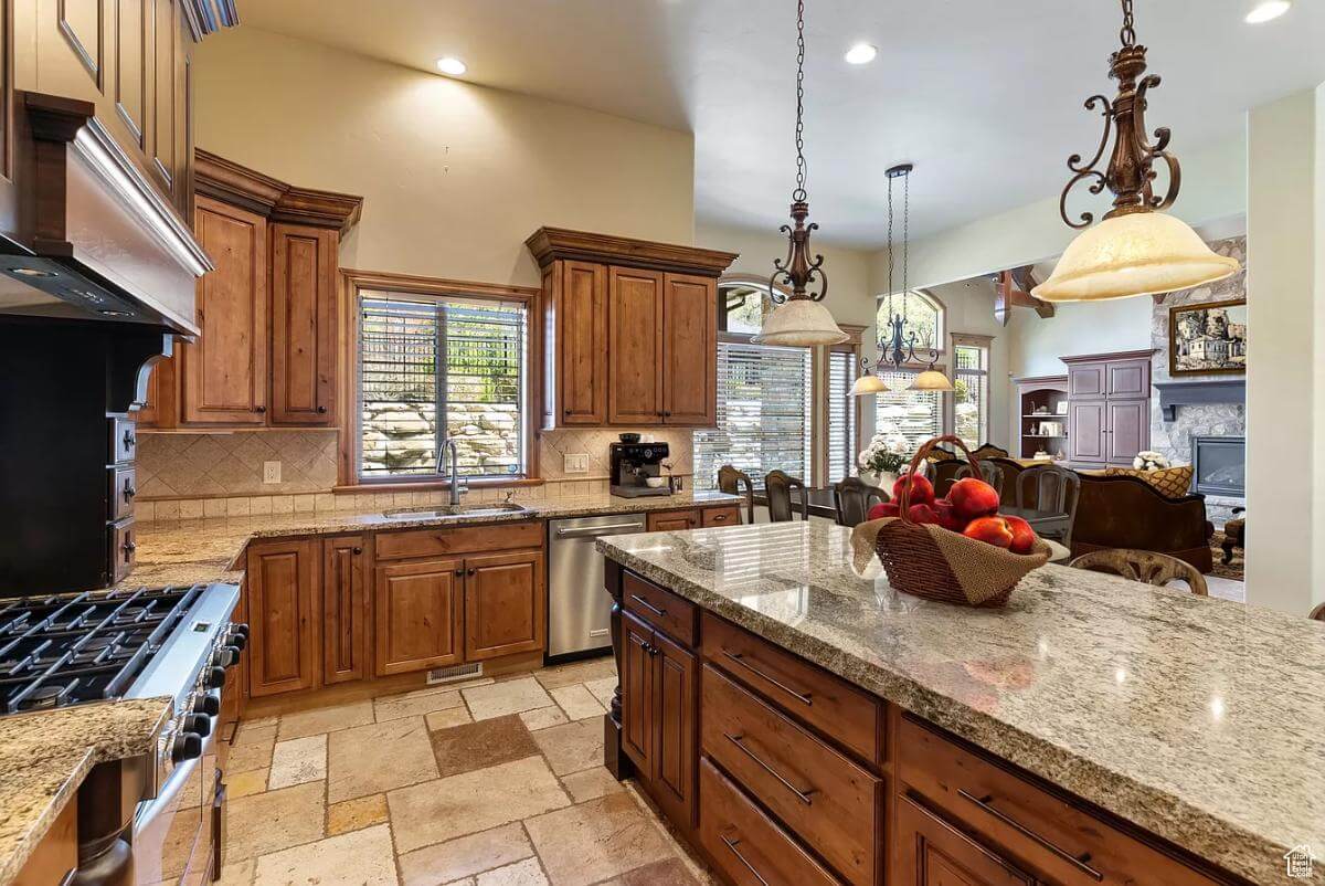 Kitchen with wooden cabinets, granite counters, and a sink set under the window.