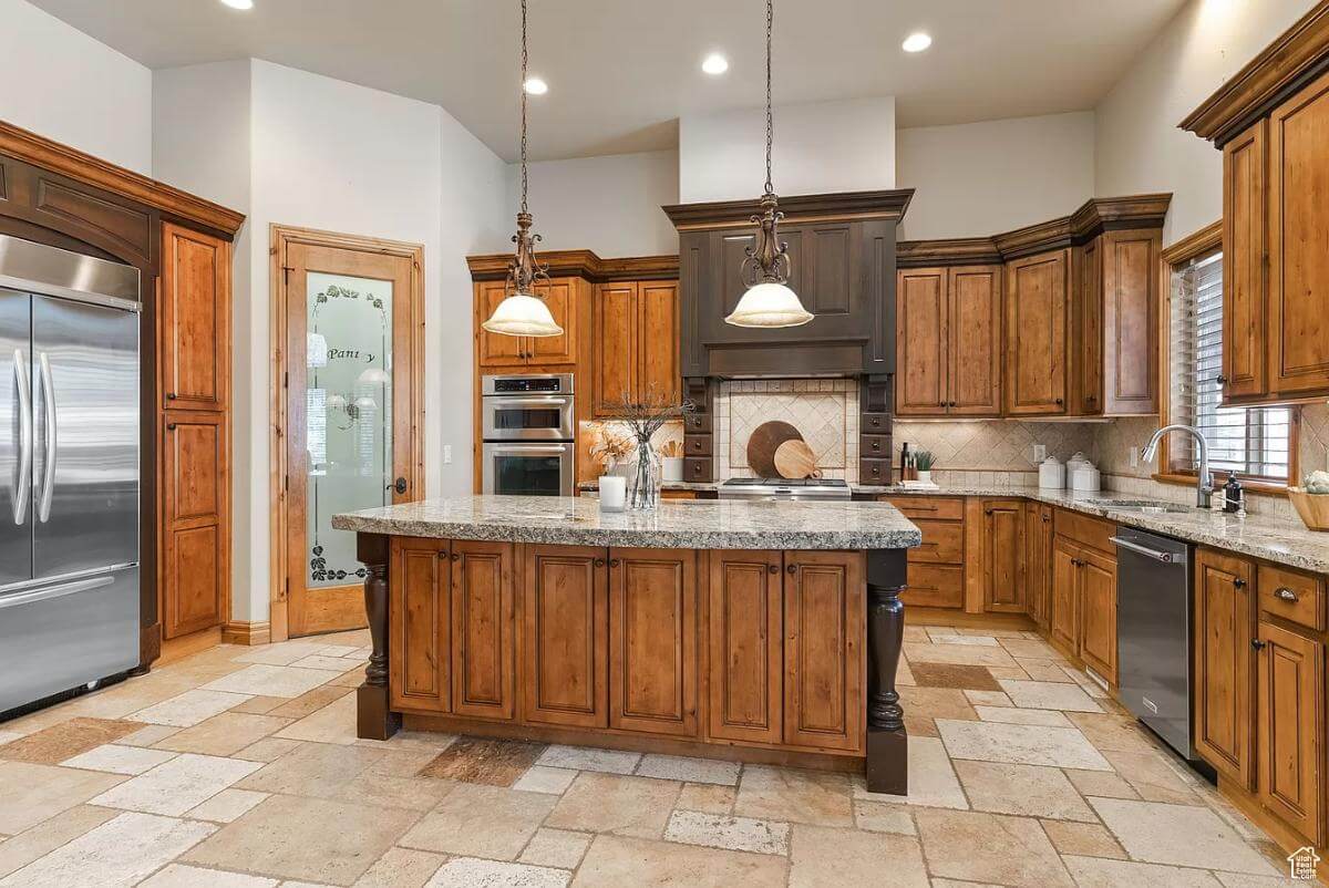 The kitchen includes stainless steel appliances, a corner pantry, and a center island.