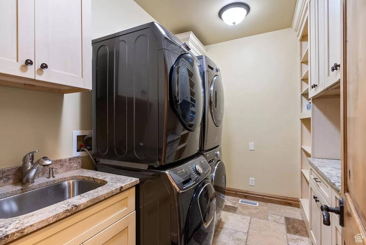 Laundry room with built-in cabinets and a utility sink.