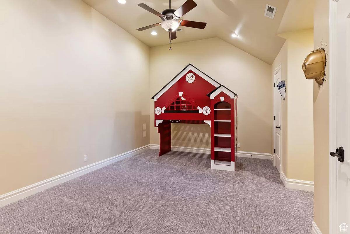 Bedroom with a custom red loft bed over a carpeted floor.