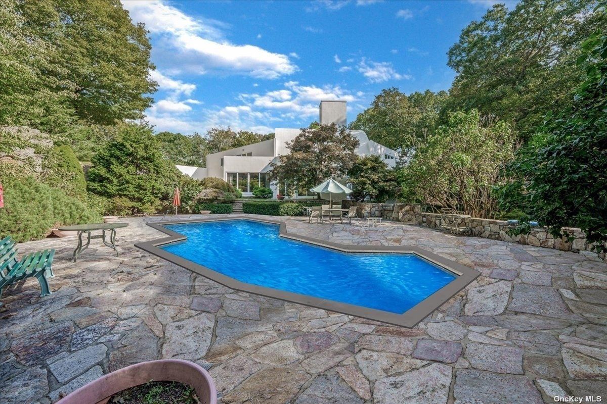 A swimming pool surrounded by plants and trees.