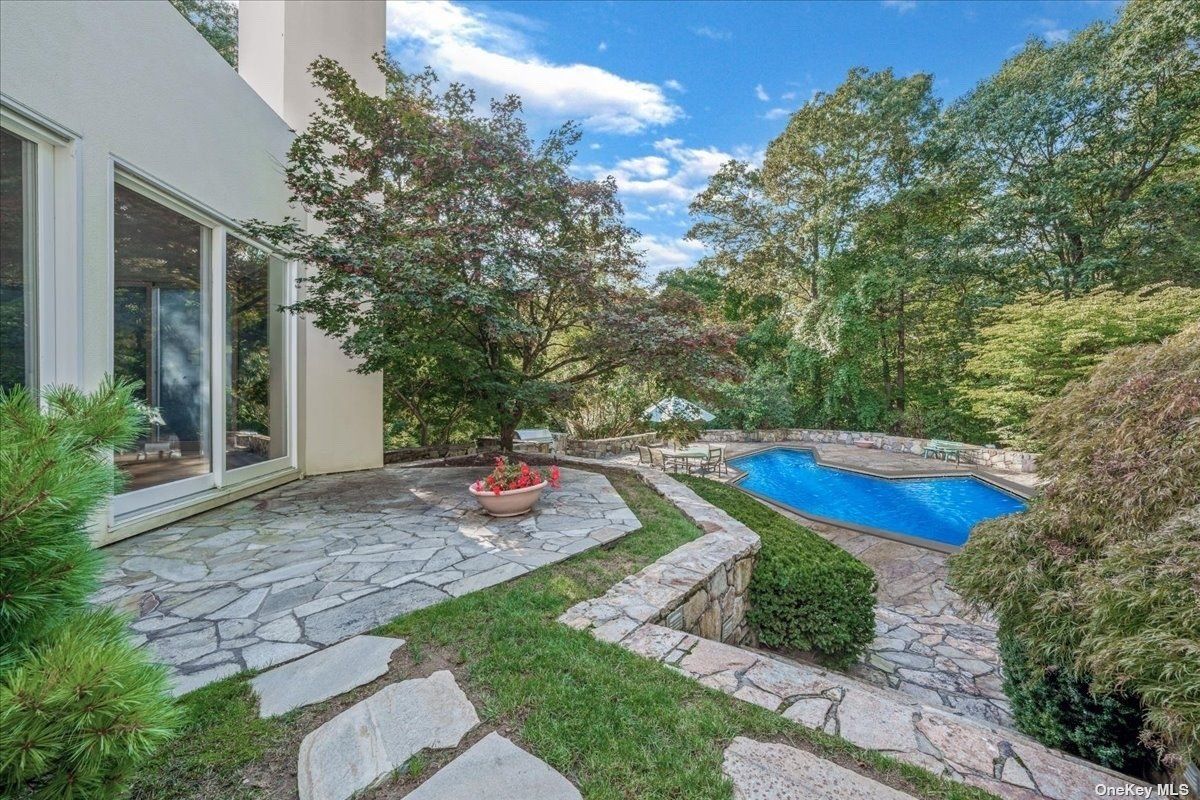 A swimming pool surrounded by plants and trees.