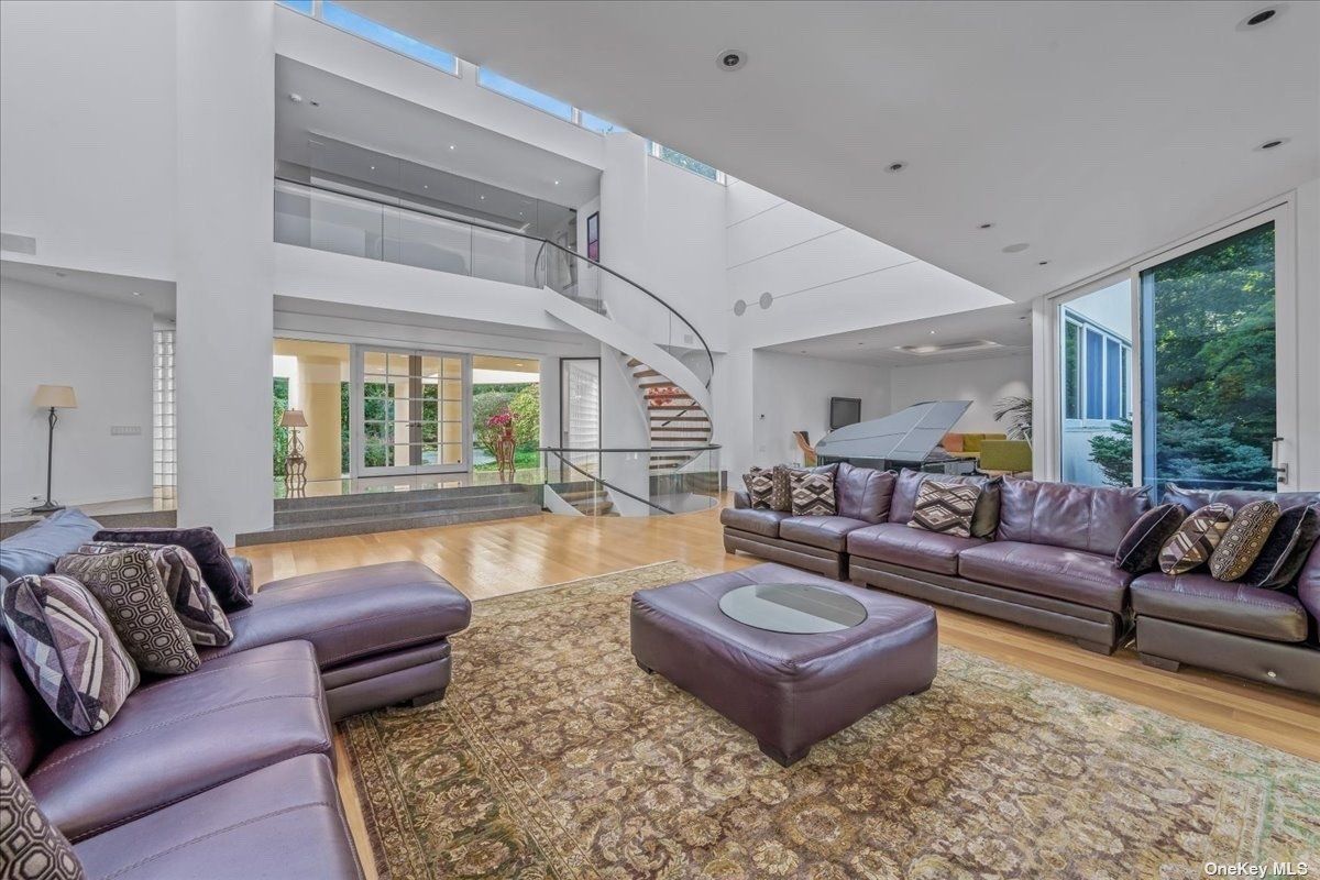 A living room with a rug, couches, and an ottoman.