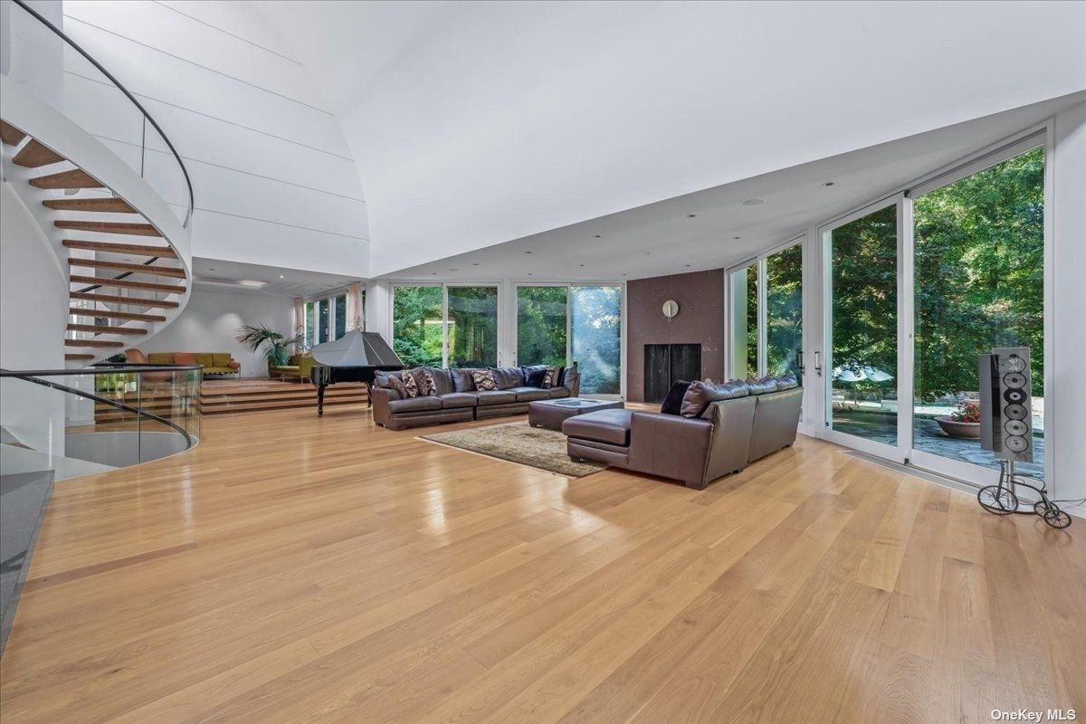 A living room with a rug, couches, and an ottoman.