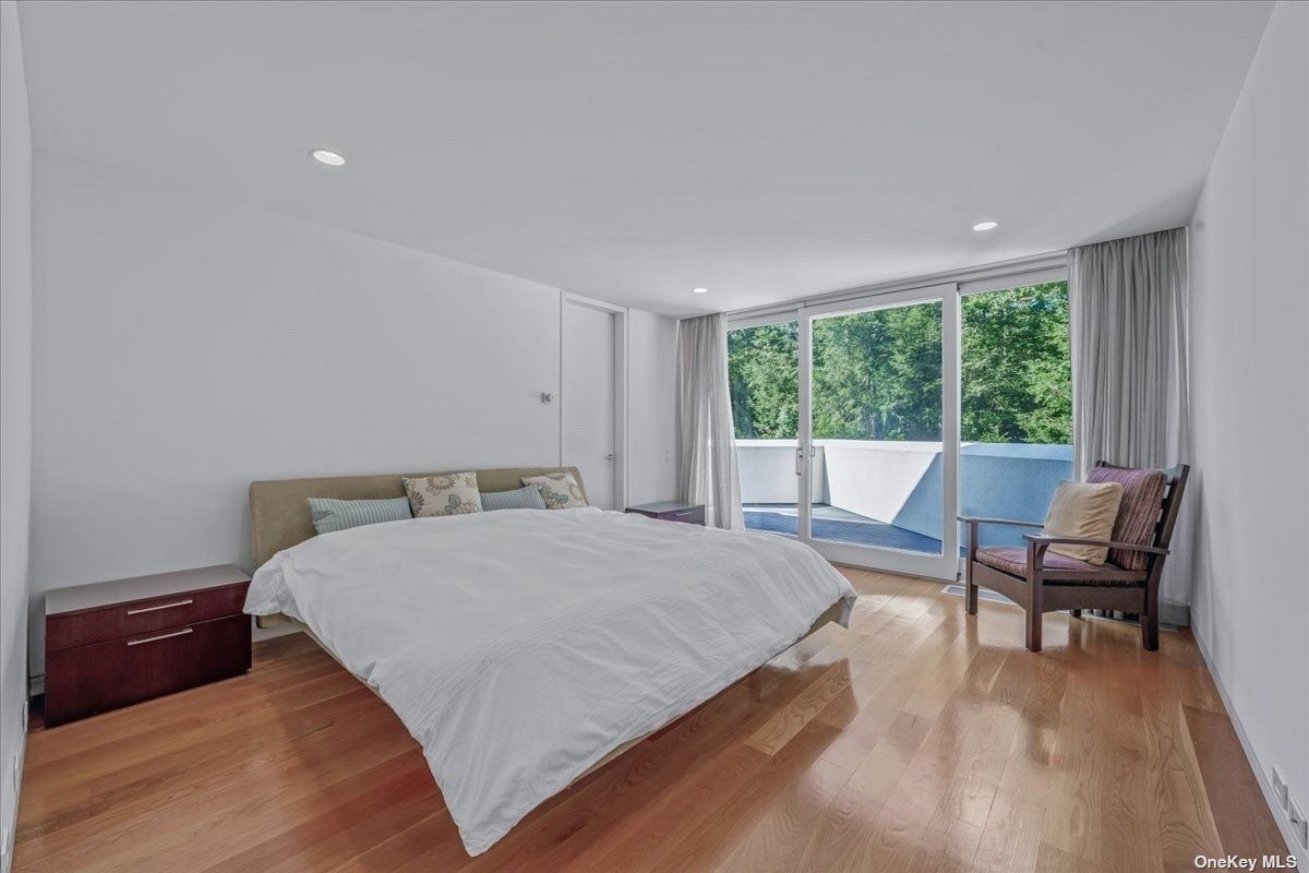 A bedroom with a bed, cabinet, and chair.