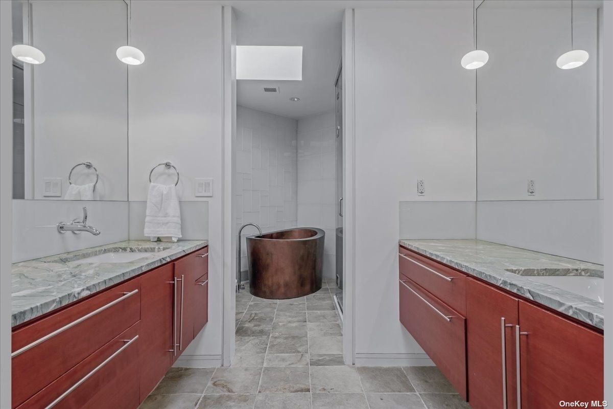 A bathroom with countertops, sink, cabinets, and bathtub.