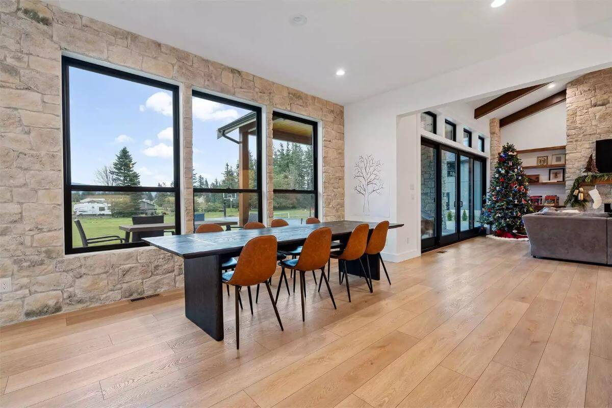 Dining area with a rectangular dining set illuminated by a trio of windows.