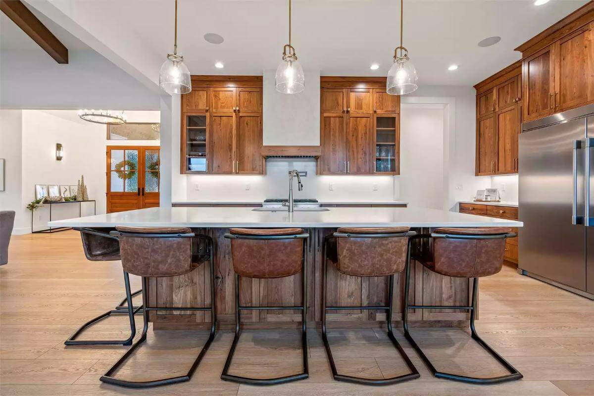 Kitchen with wooden cabinets, modern appliances, and a breakfast island fitted with a prep sink.