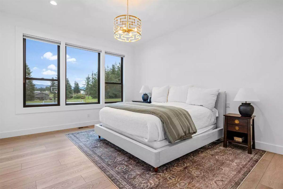 Primary bedroom with an upholstered bed and dark wood nightstands over the vintage area rug.