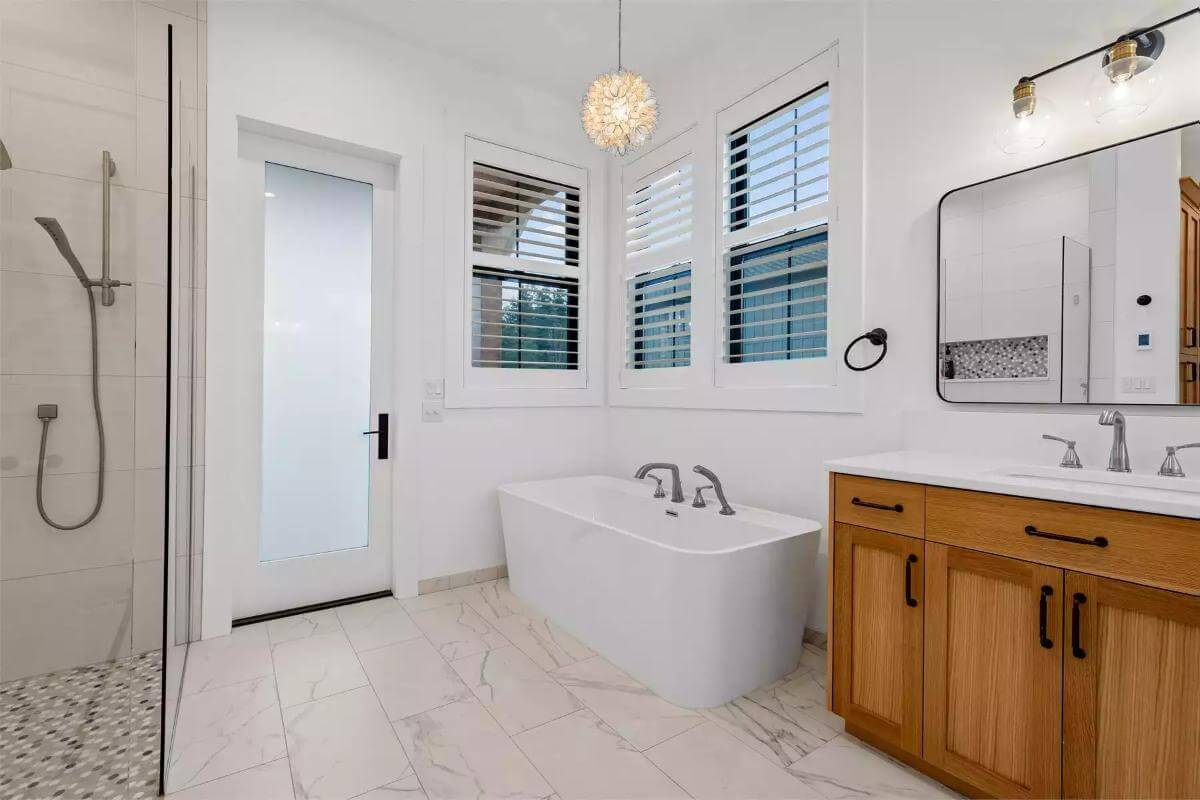 Primary bathroom with a soaking tub and a wooden vanity.