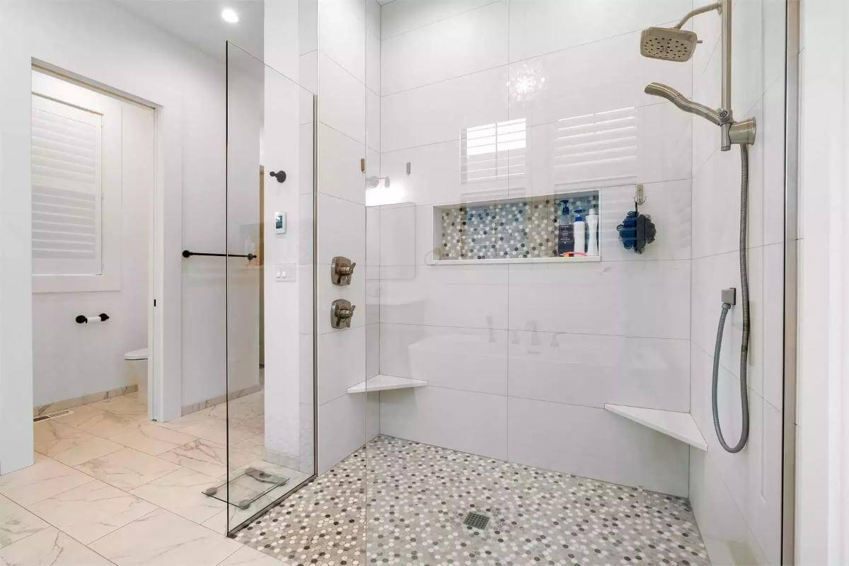 The primary bathroom includes a tiled shower with corner seats.