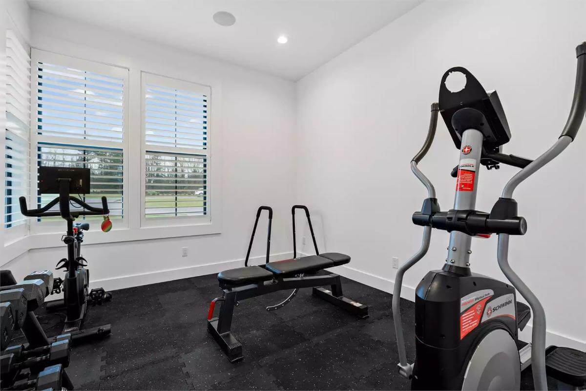 Gym with louvered windows and a vaulted ceiling.