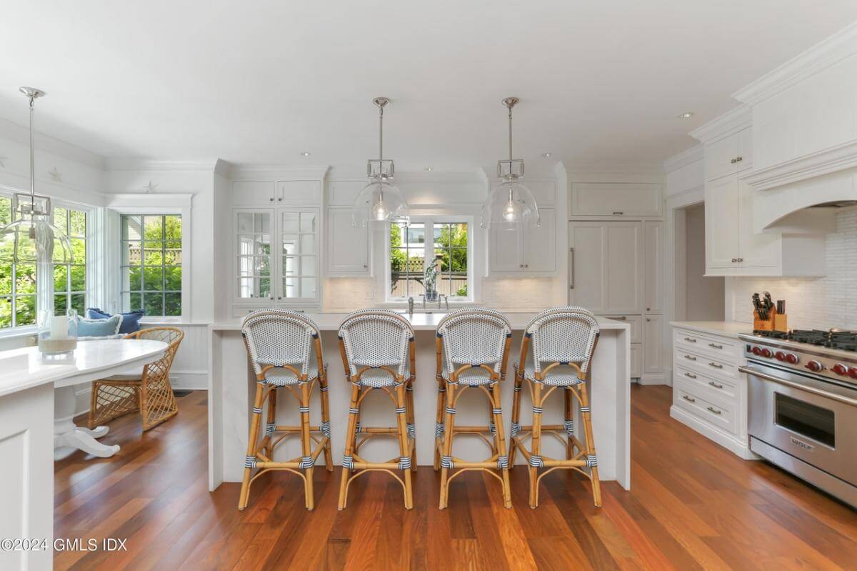 Kitchen with white cabinetry and a breakfast island with seating for four.