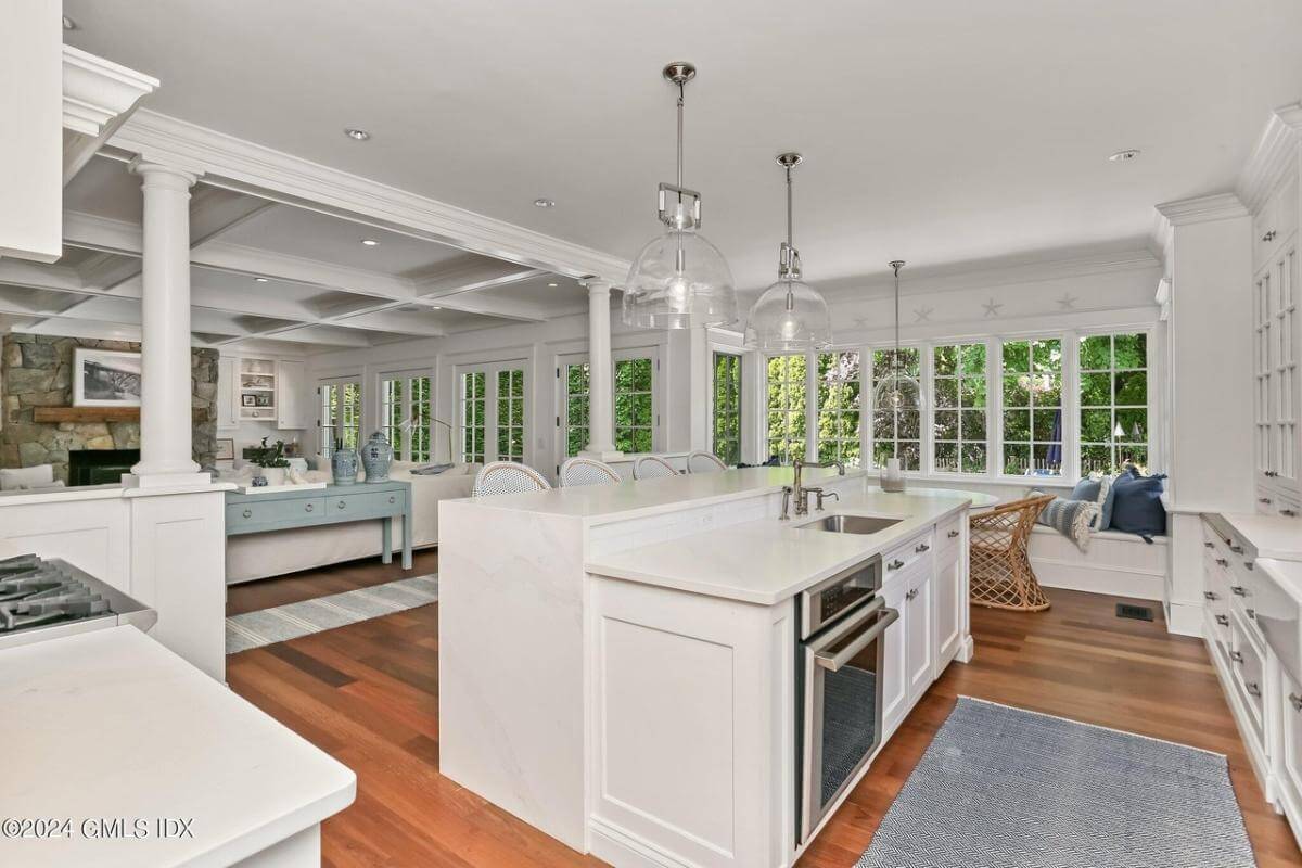 Kitchen island with a prep sink and an oven overlooking the family room.