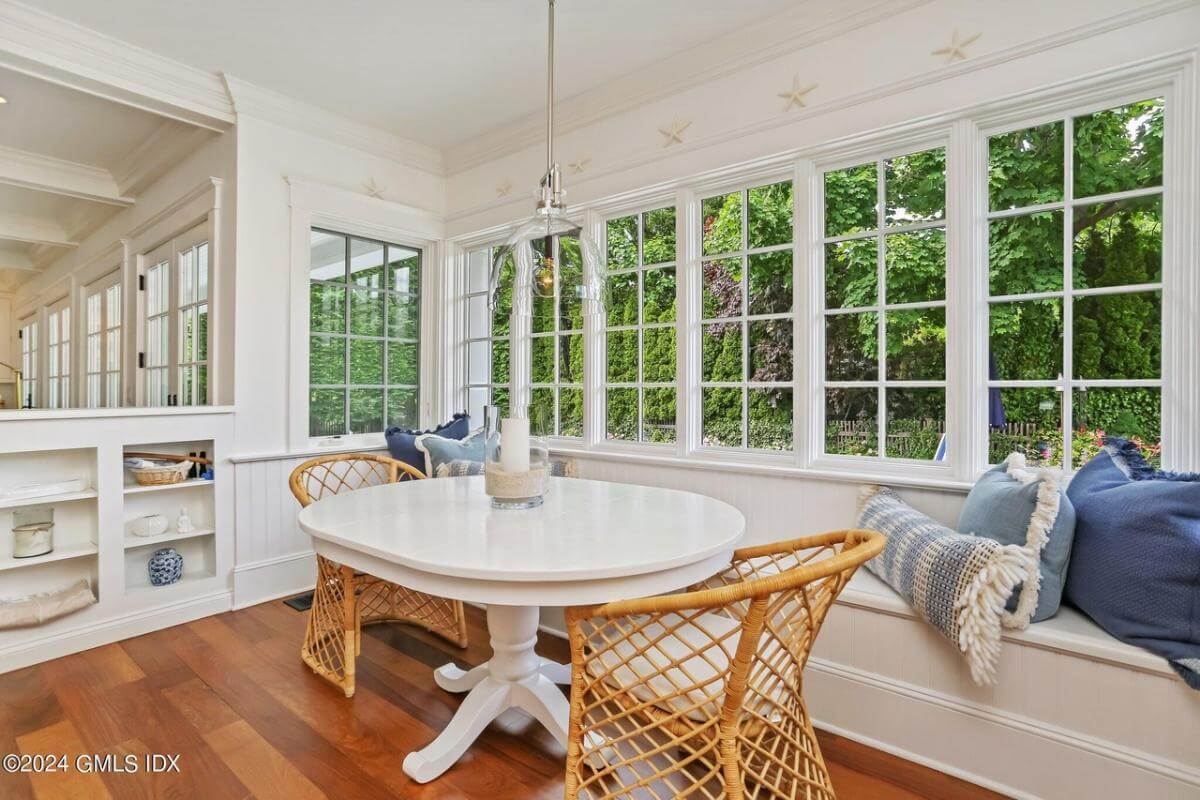 Breakfast area with rattan chairs, an oval table, and a built-in bench.