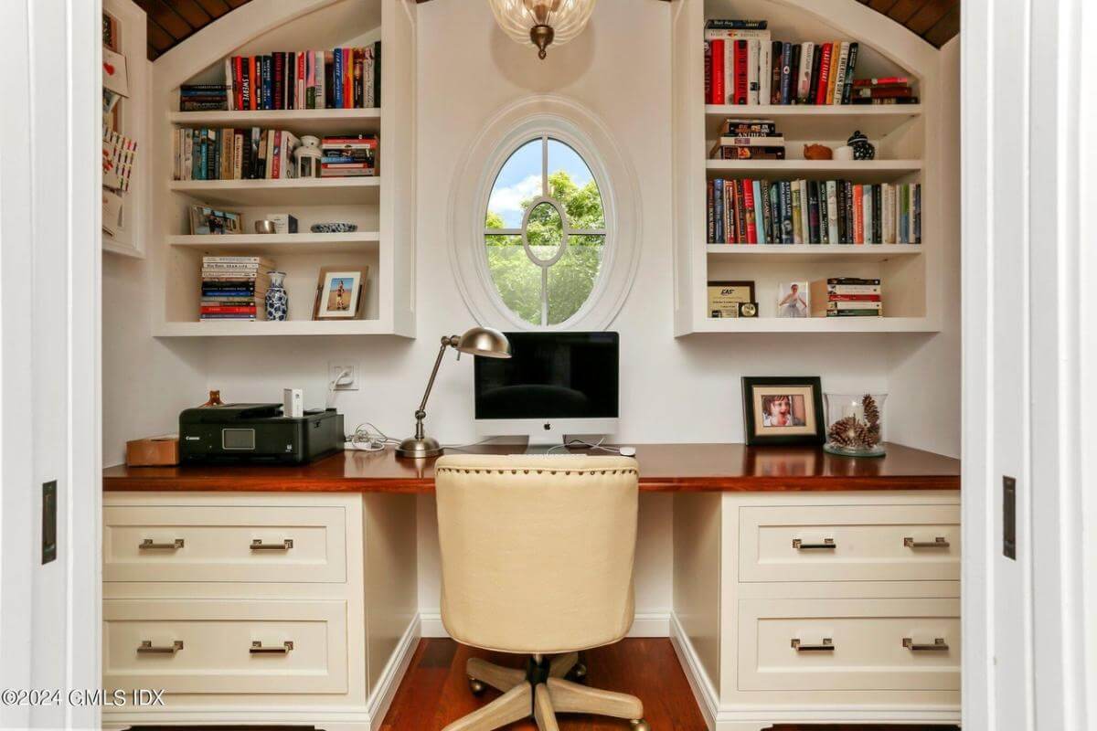 Office with a built-in desk topped by white shelves.