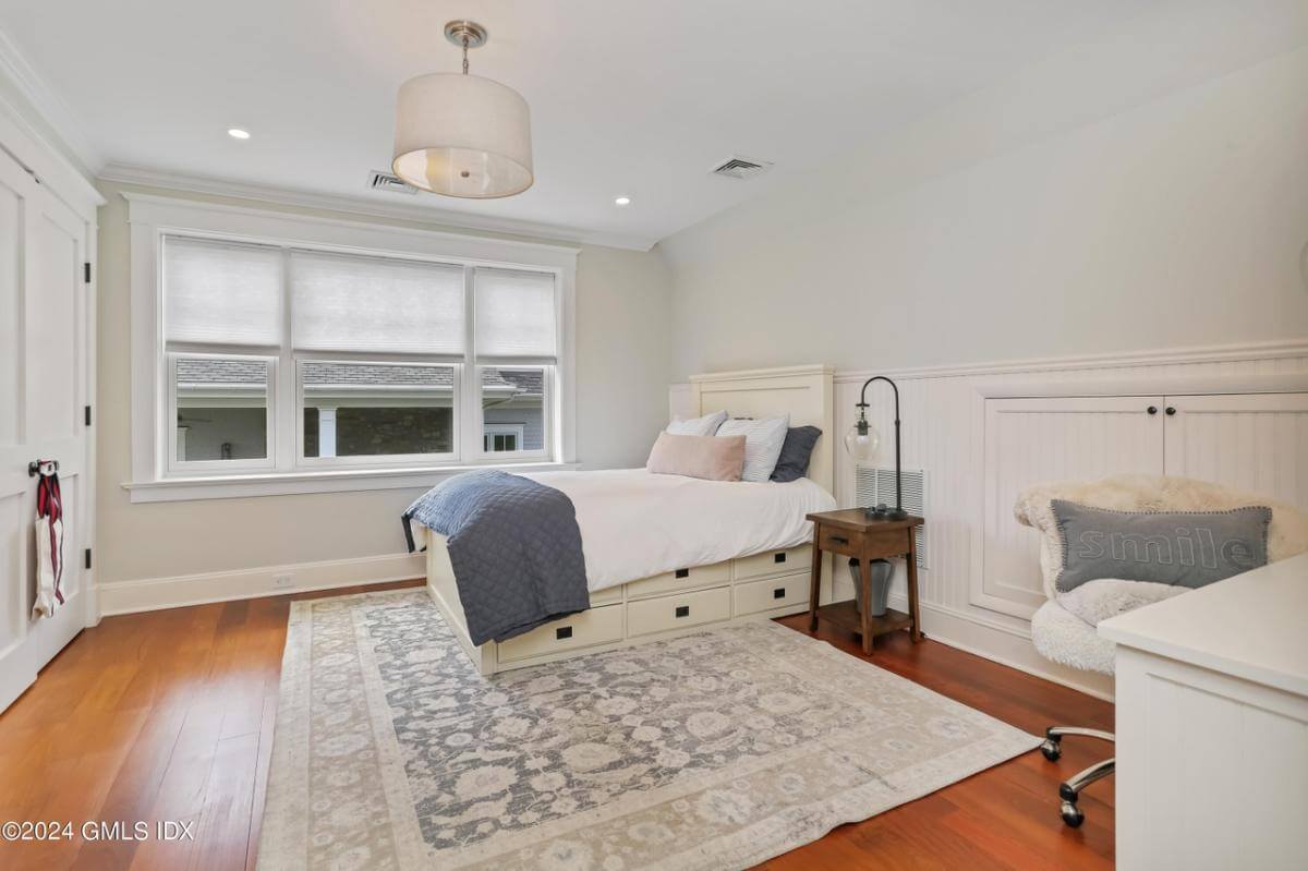 Bedroom with a white bed over the vintage area rug.