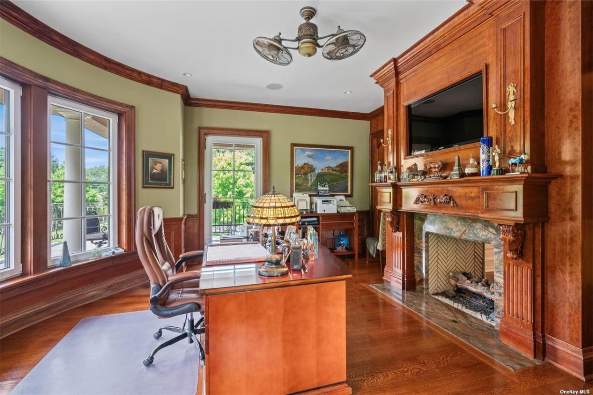 Home office with a TV and a fireplace.