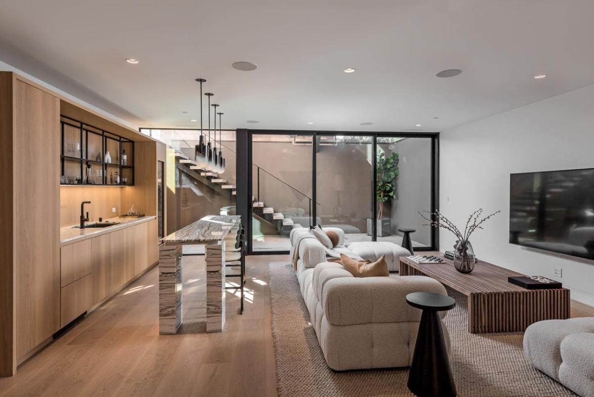 Entertainment room with couches, a TV and a bar.