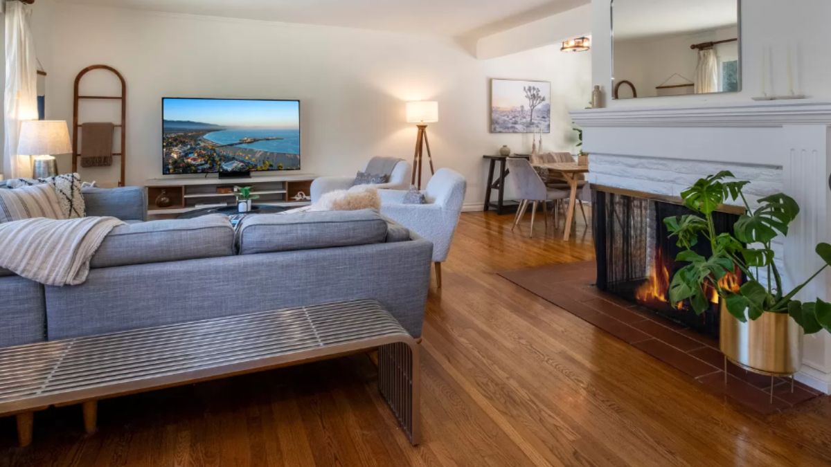 A living room with chairs, couches, a TV, and a fireplace.