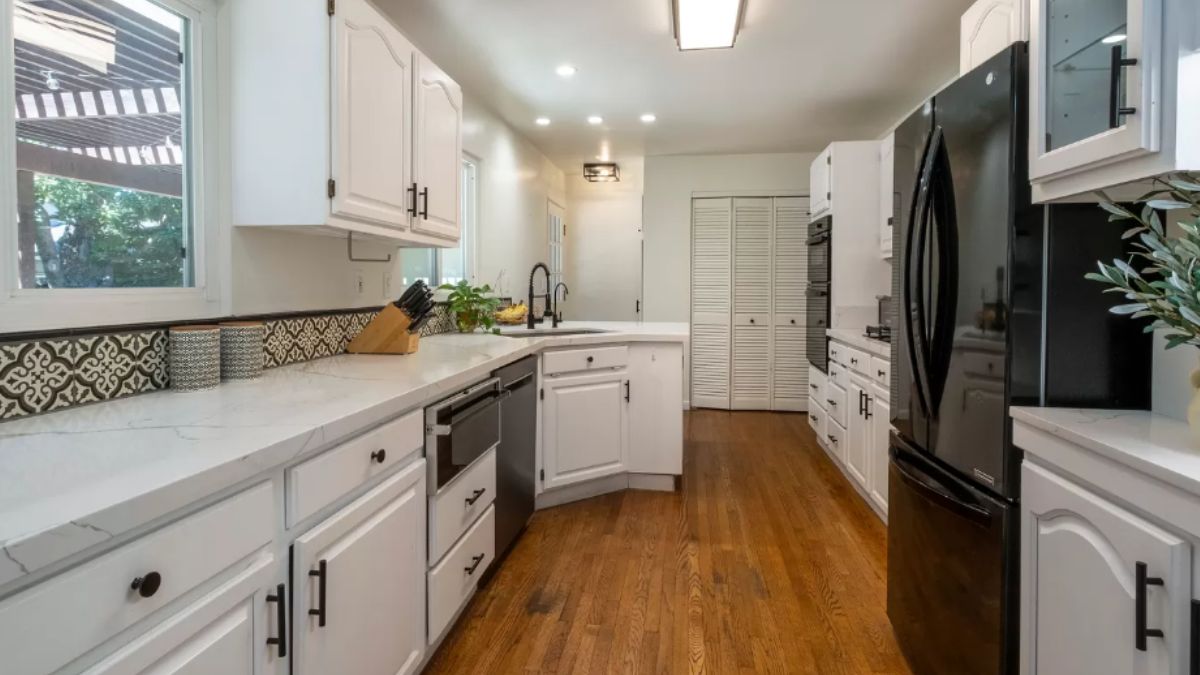 A kitchen with countertops, a sink, cabinets, and kitchen appliances.